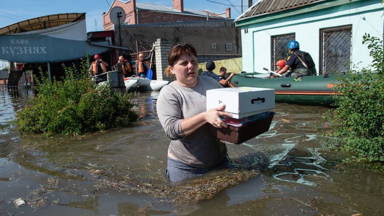 A woman wades through waist-high water 
